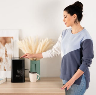 Miamo Aroma Maxi Cube diffuser with woman, creating a refined and aromatic atmosphere